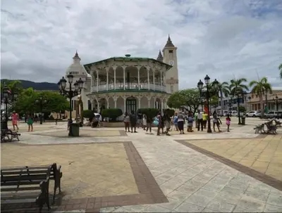 a large building with people walking in front of it at Hotel Kevin in San Felipe de Puerto Plata