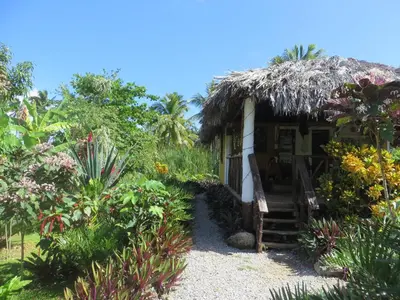 a small house with a straw roof at Villa La Caleta in Las Galeras