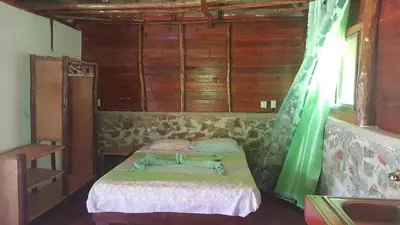 a bedroom with a bed in a room with wooden walls at Villa La Caleta in Las Galeras