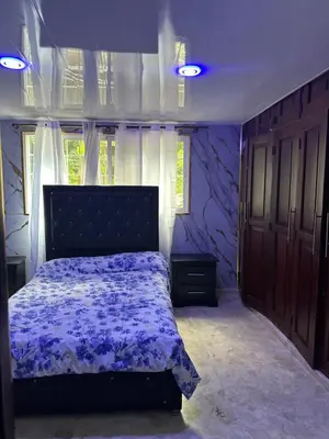 a bedroom with a bed with a purple comforter at Mar azul 401 in San Felipe de Puerto Plata