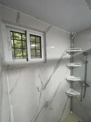 a bathroom with white marble walls and a window at Mar azul 401 in San Felipe de Puerto Plata