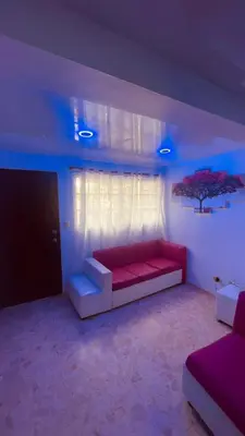 a living room with a red couch and a window at Mar azul 401 in San Felipe de Puerto Plata