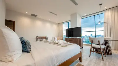 a bedroom with a bed and a desk and a television at Mauad Hotel Boutique in Santo Domingo