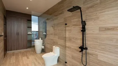 a bathroom with a shower with a toilet in it at Mauad Hotel Boutique in Santo Domingo