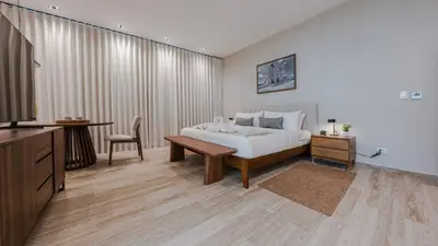 a bedroom with a bed and a table and a television at Mauad Hotel Boutique in Santo Domingo