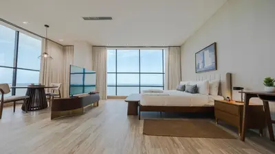 a hotel room with a bed and a table and a dining room at Mauad Hotel Boutique in Santo Domingo