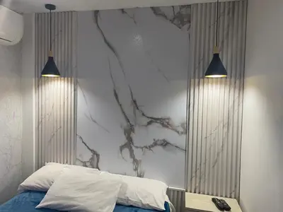 a bedroom with a bed and two lights on a wall at Apartamentos Magallanes Romana in La Romana