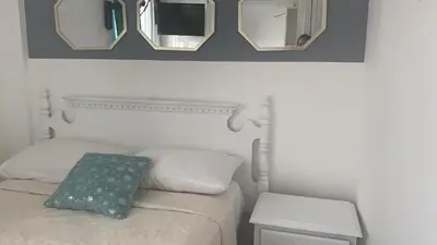 a bedroom with a bed with three mirrors above it at Apartamentos Magallanes Romana in La Romana