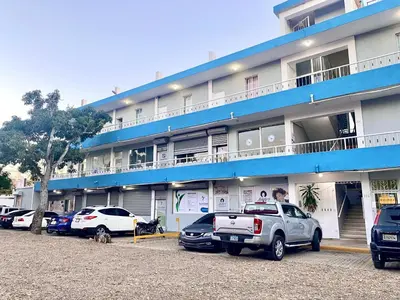 a large building with cars parked in front of it at Apartamentos Magallanes Romana in La Romana