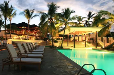 a row of lounge chairs next to a swimming pool at Casa de Campo Resort & Villas in La Romana