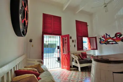 a living room with red shutters on the door at La Puerta Roja Guest House in Santo Domingo