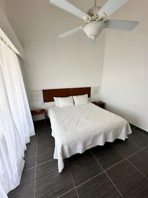 a bedroom with a white bed with a ceiling fan at Spectacular Ocean View Top Floor 1-Bedroom Condo, Vista Mare, Samana DR in Santa Bárbara de Samaná