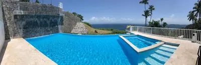 a swimming pool with a view of the ocean at Spectacular Ocean View Top Floor 1-Bedroom Condo, Vista Mare, Samana DR in Santa Bárbara de Samaná