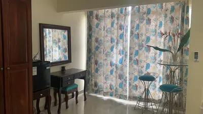 a room with a curtain and a desk and a window at Hotel Luis V Santo Domingo in Santo Domingo