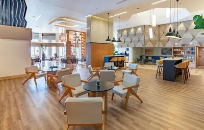 a lobby with tables and chairs in a building at Crowne Plaza Santo Domingo by IHG in Santo Domingo