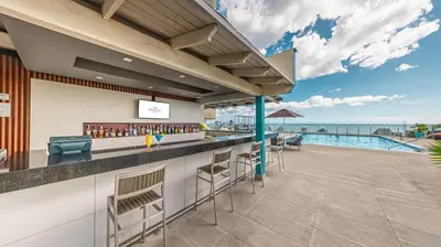 an outdoor bar with a view of a pool at Crowne Plaza Santo Domingo by IHG in Santo Domingo