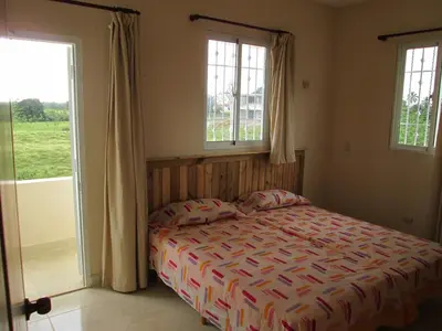a bedroom with a bed and two windows at Villa Mambo in Patrana