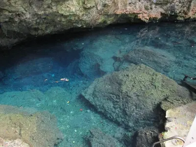a pool of blue water with rocks in a cave at Villa Mambo in Patrana