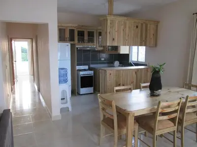 a kitchen with a wooden table and a table and chairs at Villa Mambo in Patrana