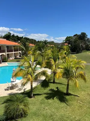 a group of palm trees next to a swimming pool at Residencial Green Paradise at Metro Country Club Juan Dolio - 2 Bedroom with Balcony in Juan Dolio
