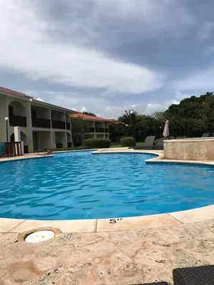 a large blue swimming pool in a resort at Residencial Green Paradise at Metro Country Club Juan Dolio - 2 Bedroom with Balcony in Juan Dolio