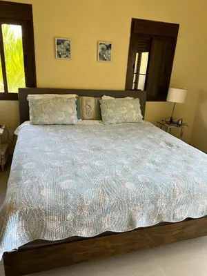 a large bed with a blue comforter in a bedroom at Residencial Green Paradise at Metro Country Club Juan Dolio - 2 Bedroom with Balcony in Juan Dolio