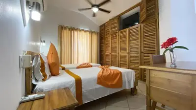a bedroom with a bed and a desk and a television at Albachiara Hotel - Las Terrenas in Las Terrenas