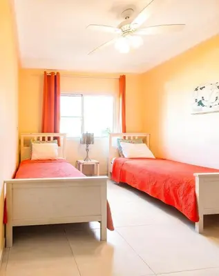 a bedroom with two beds and a ceiling fan at Caribbean Treasure in Punta Cana