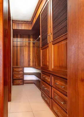 a walk in closet with wooden cabinets and a tile floor at Caribbean Treasure in Punta Cana