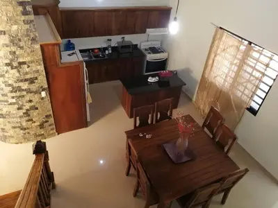 a kitchen and dining room with a wooden table and chairs at Villa Laura Jarabacoa in Jarabacoa