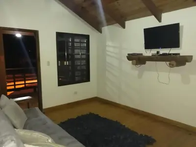 a living room with a couch and a tv on a wall at Villa Laura Jarabacoa in Jarabacoa