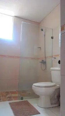 a bathroom with a toilet and a glass shower at Casa D9 in Santo Domingo