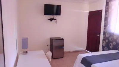 a bedroom with a bed and a tv on the wall at Casa D9 in Santo Domingo