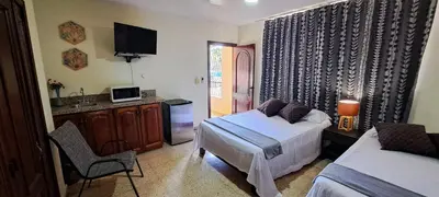 a bedroom with a bed and a desk and a tv at Casa D9 in Santo Domingo