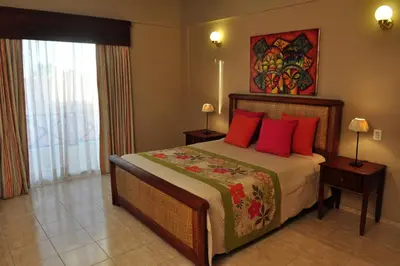 a bedroom with a large bed with red pillows at Hotel & Casino Flamboyan in Punta Cana