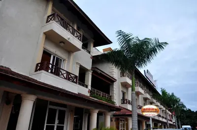 a building with a palm tree in front of it at Hotel & Casino Flamboyan in Punta Cana