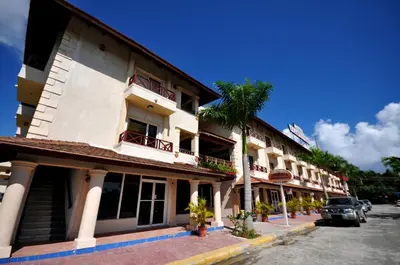 a building with cars parked in front of it at Hotel & Casino Flamboyan in Punta Cana
