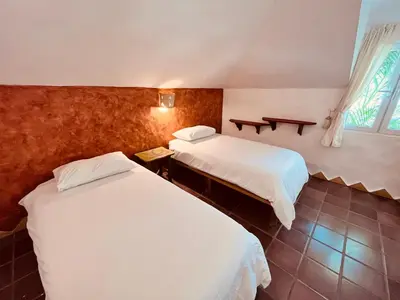 a hotel room with two beds and a window at Hotel La Tortuga in Las Terrenas