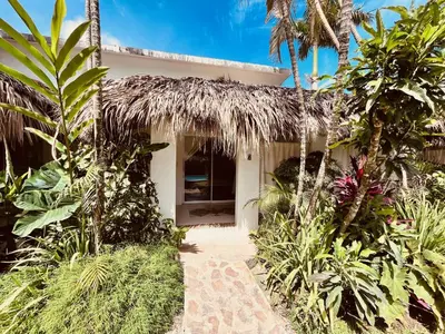 a tropical house with a thatched roof at Hotel La Tortuga in Las Terrenas