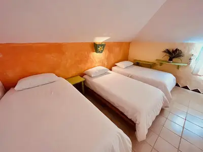 a hotel room with three beds in a room at Hotel La Tortuga in Las Terrenas
