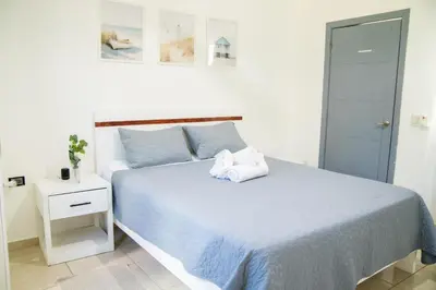 a white bedroom with a bed with blue sheets at Hotel Casa Pierretta in Las Terrenas
