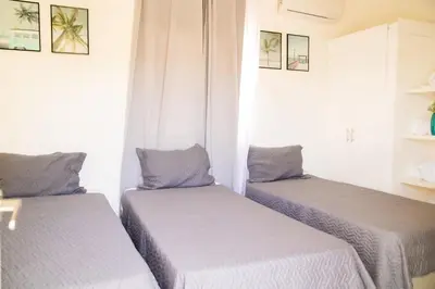 two twin beds in a room with white walls at Hotel Casa Pierretta in Las Terrenas
