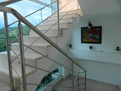 a staircase in a house with a glass railing at Figaro Hotel Samana in Santa Bárbara de Samaná