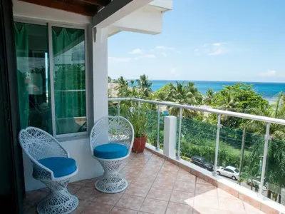 a balcony with chairs and a view of the ocean at Hotel Neptuno Refugio in Boca Chica