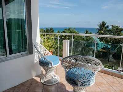 two chairs on a balcony with a view of the ocean at Hotel Neptuno Refugio in Boca Chica