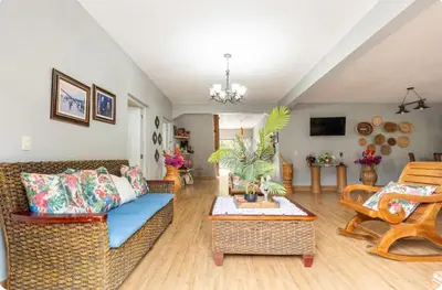 a living room with a couch and a table at Cabaña Don Tobo Jarabacoa RD in Jarabacoa