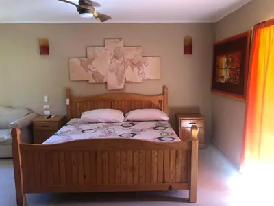 a bedroom with a wooden bed with two pink pillows at Hotel Cambri in Nagua