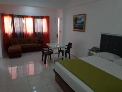 a bedroom with a bed and a table and a couch at Royal Palace Hotel in Santo Domingo