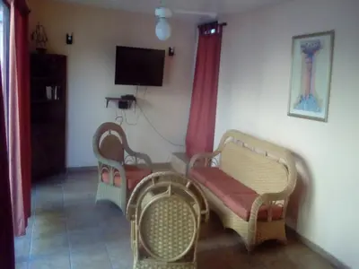 a living room with two chairs and a tv at Perla de Sosua in Sosúa