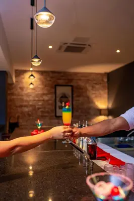 two people are holding a drink at a bar at Coral Costa Caribe Beach Resort - All Inclusive in Juan Dolio